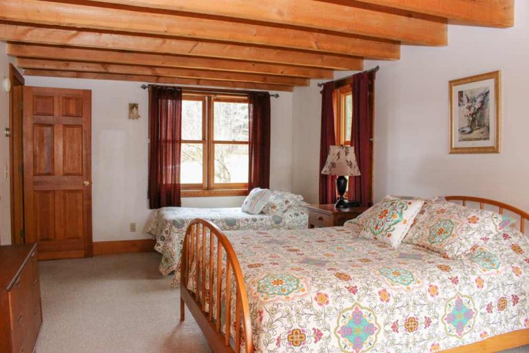 Pond House downstairs bedroom with two beds | Sterling Ridge Log Cabin Resort