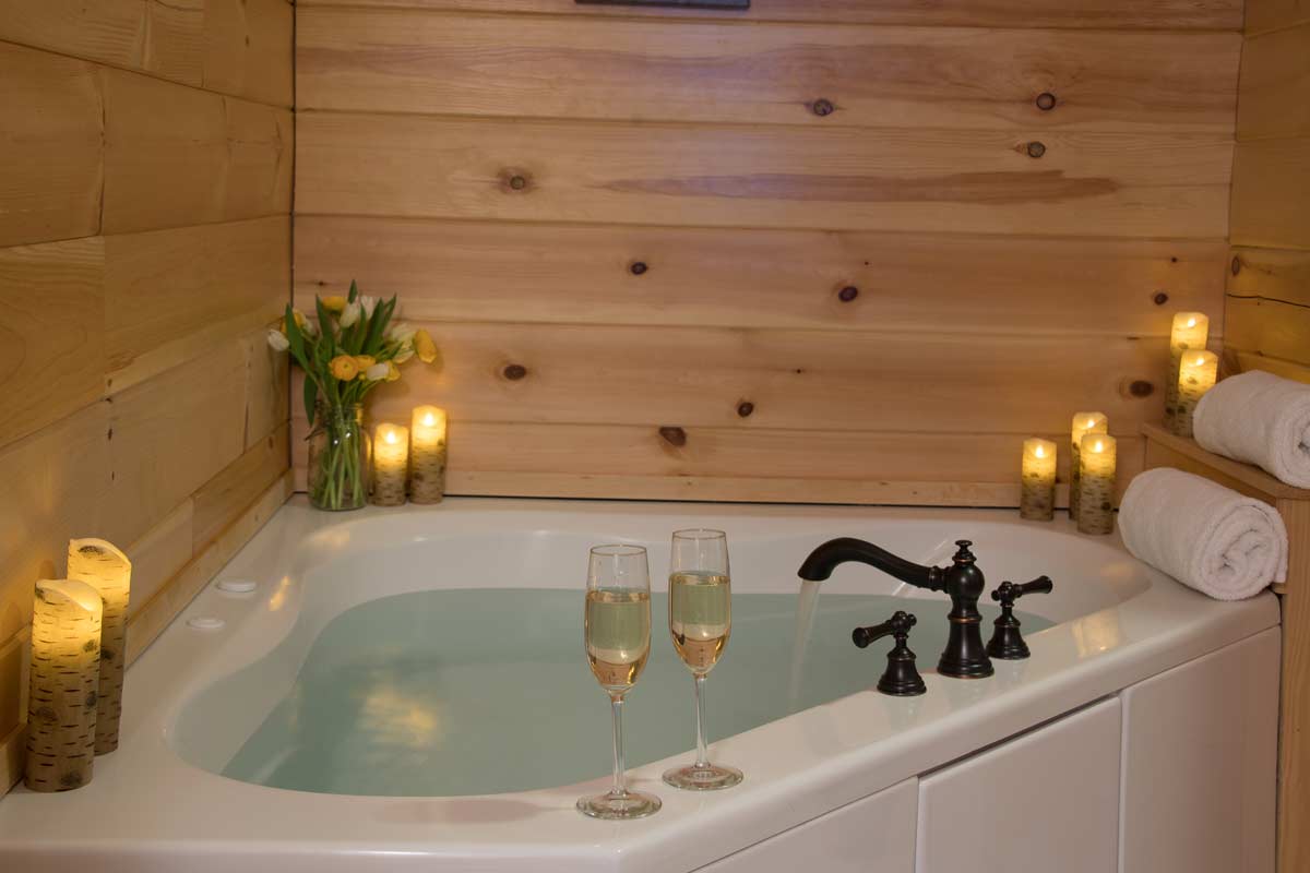 Romantic whirlpool tub with champagne and candle lit | Sterling Ridge Log Cabin Resort