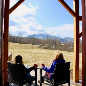 Two women having coffee with view of mt mansfield | sterling ridge resort