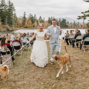 bride and groom walking their dogs down the aisle